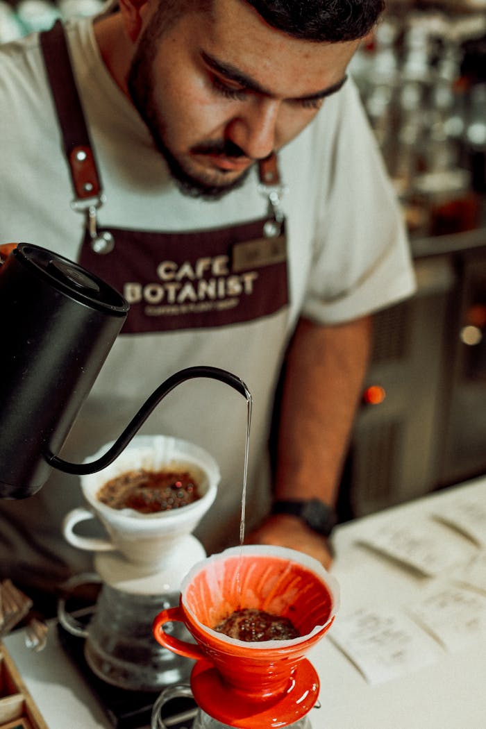 A barista carefully pours coffee in a vibrant cafe setting in Baku, Azerbaijan.