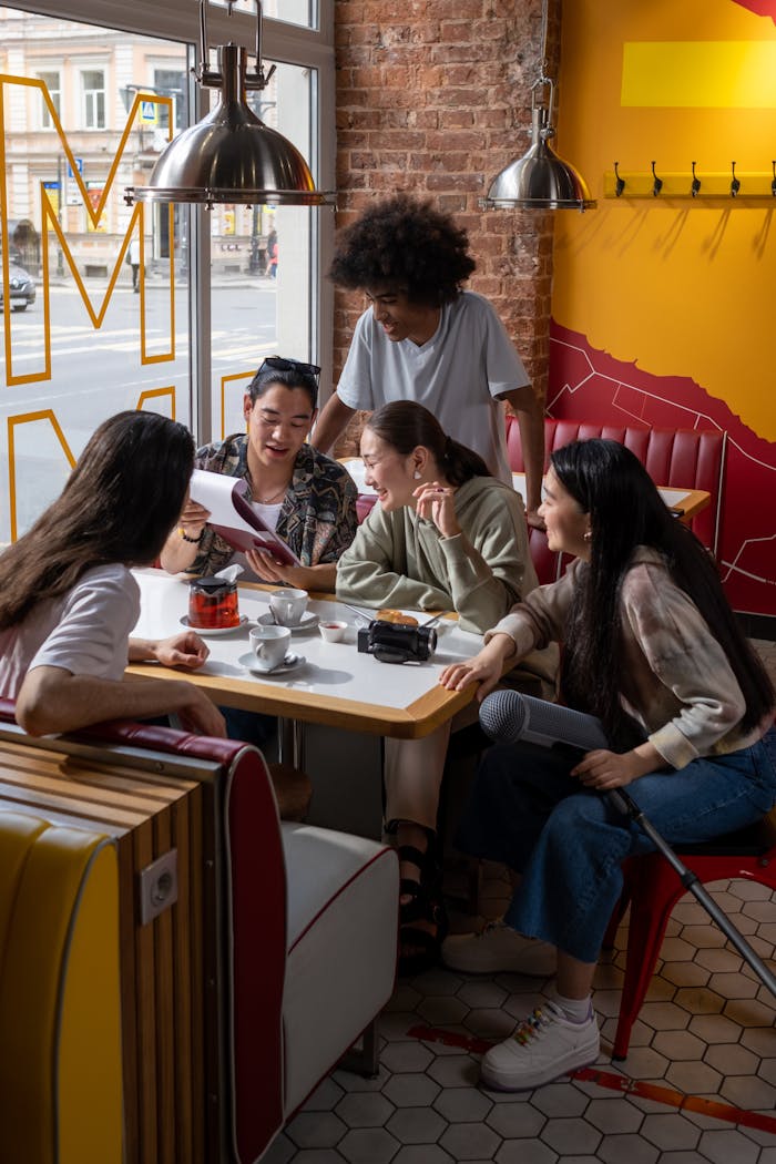 Services Group of young adults enjoying coffee and conversation in a lively, modern café setting.